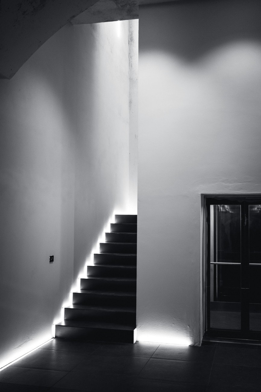 A staircase rising through illuminated levels, one flight at a time